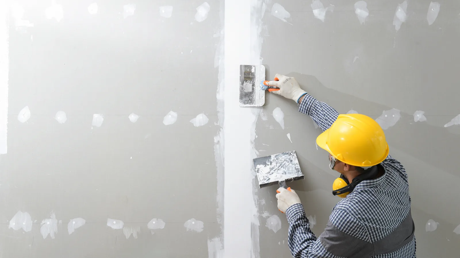 Drywall finisher applying joint compound during an interior renovation